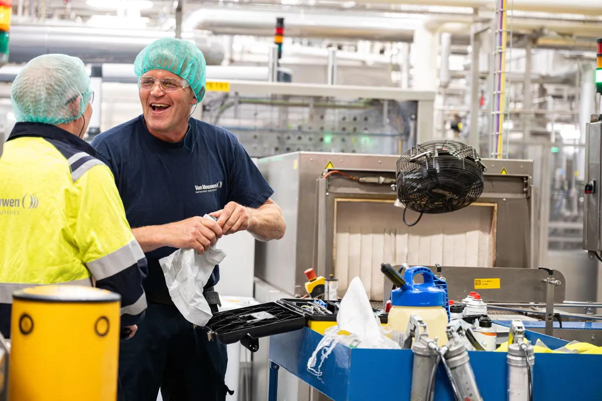 Smeertechnisch monteur van Van Meeuwen aan het werk aan een productielijn