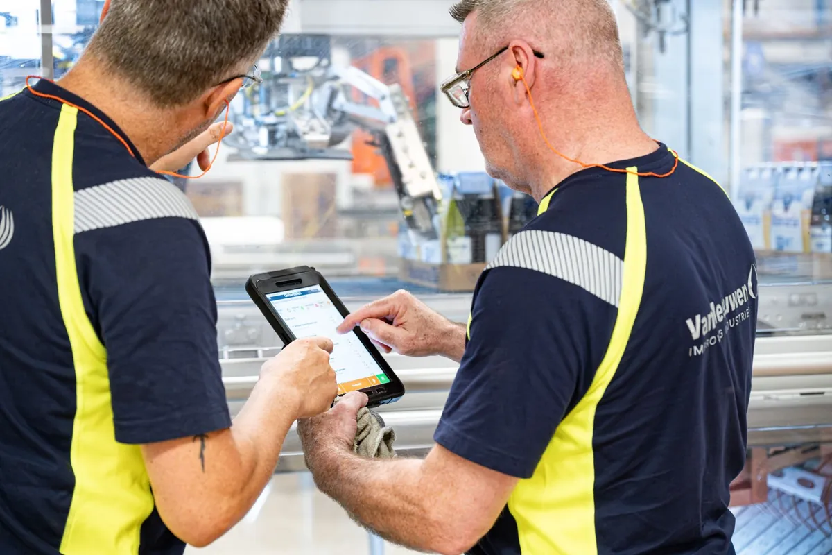 Twee monteurs bekijken smeertaken op de S)MAXX-tablet